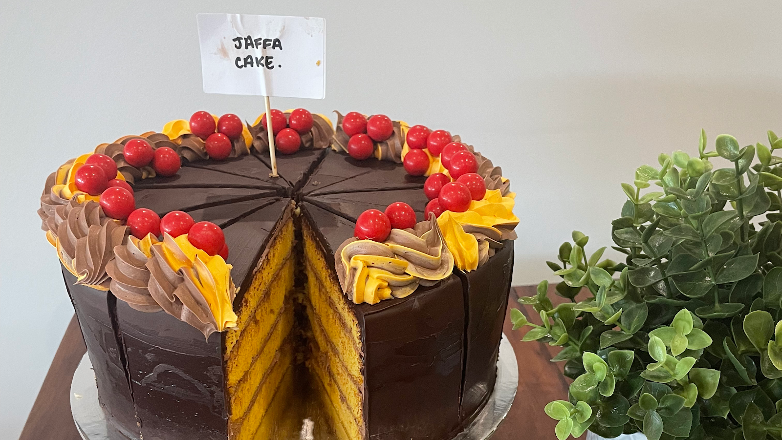 A chocolate and orange Jaffa layer cake topped with cherries