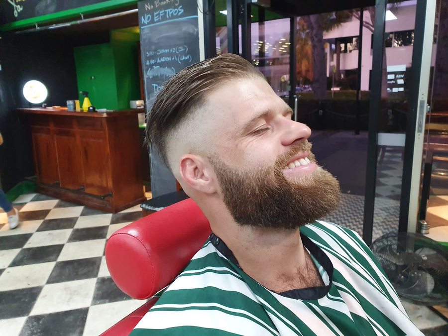 A relaxed customer with a clean, groomed beard after a face shave