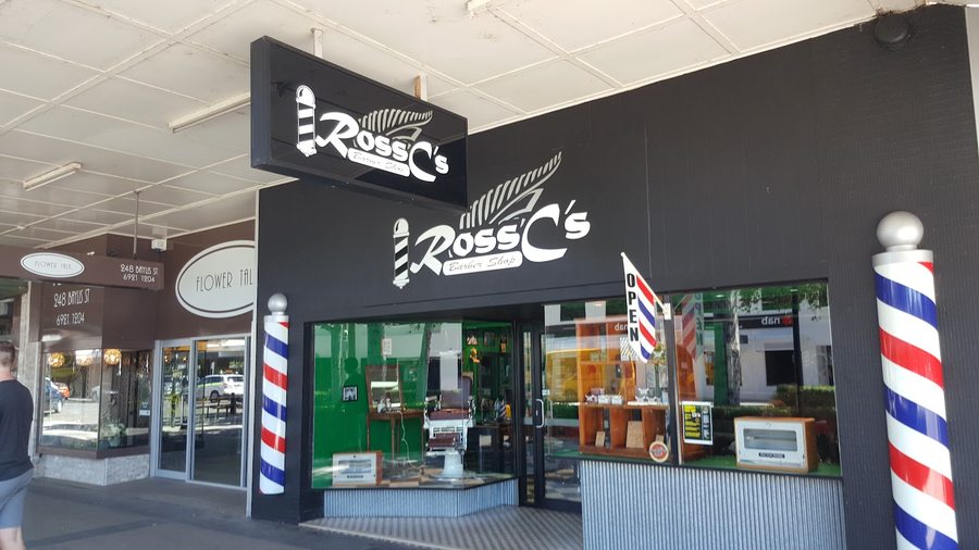 Ross C's daytime shopfront on Baylis Street with twin barber poles and an OPEN flag