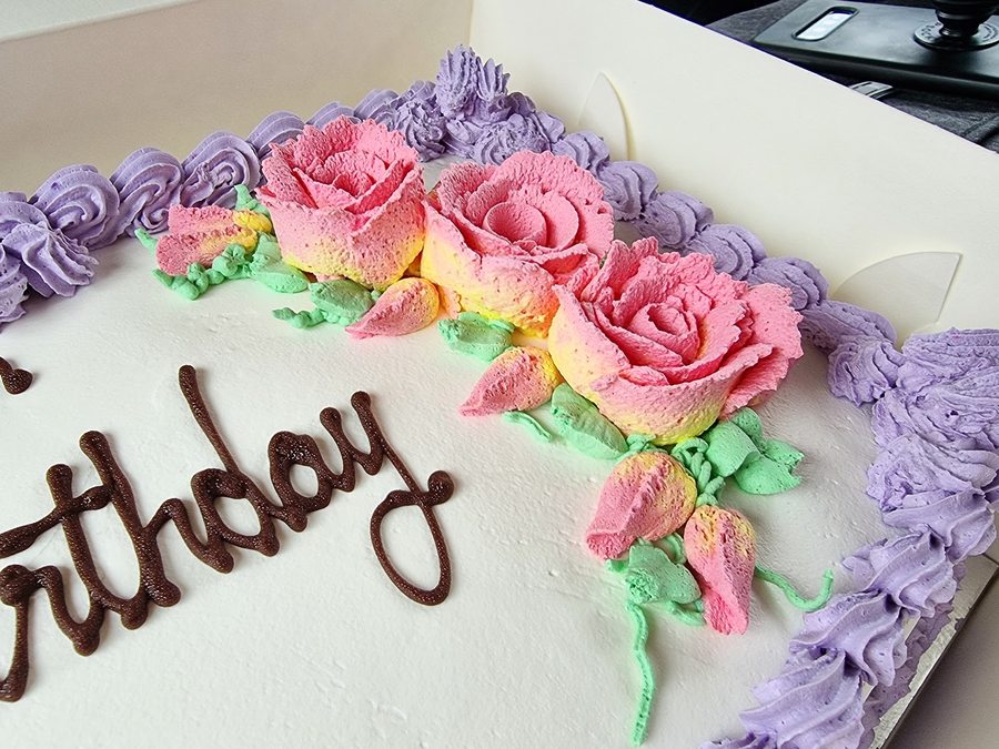 A buttercream-rose celebration cake being decorated at O'Donnell's Bakehouse