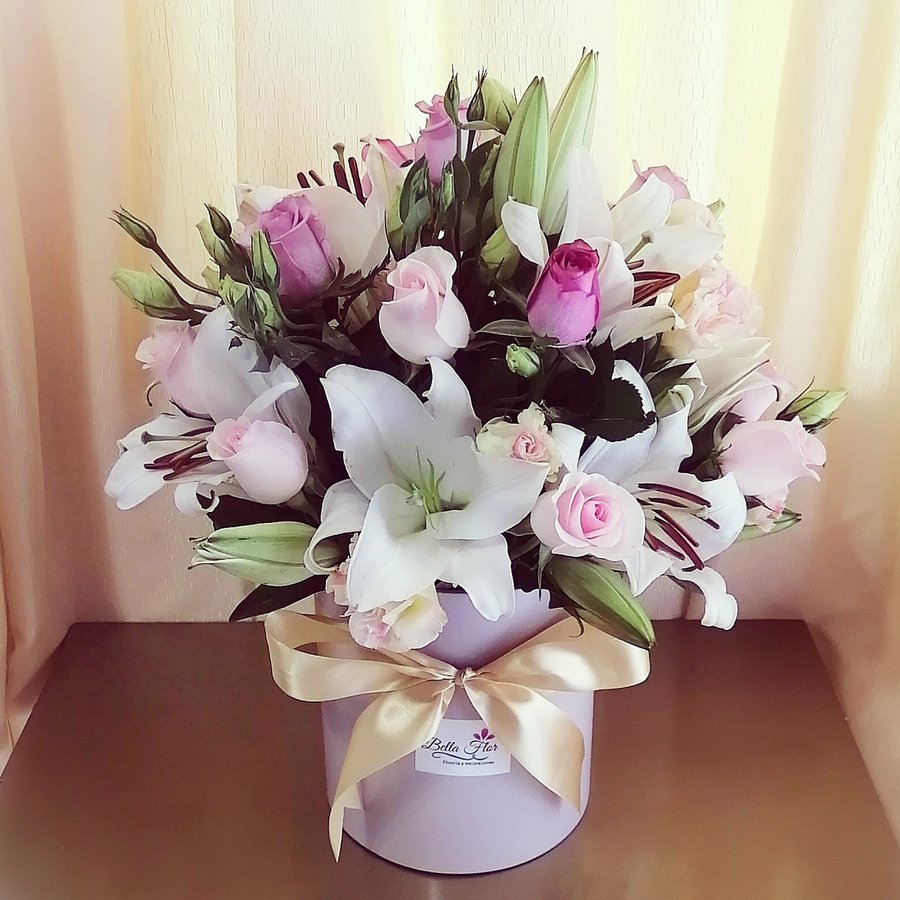 Arreglo en caja redonda con rosas y lirios, con lazo de Bella Flor.