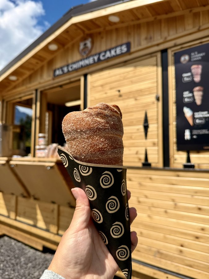 A classic cinnamon-sugar chimney cake in a branded wrap