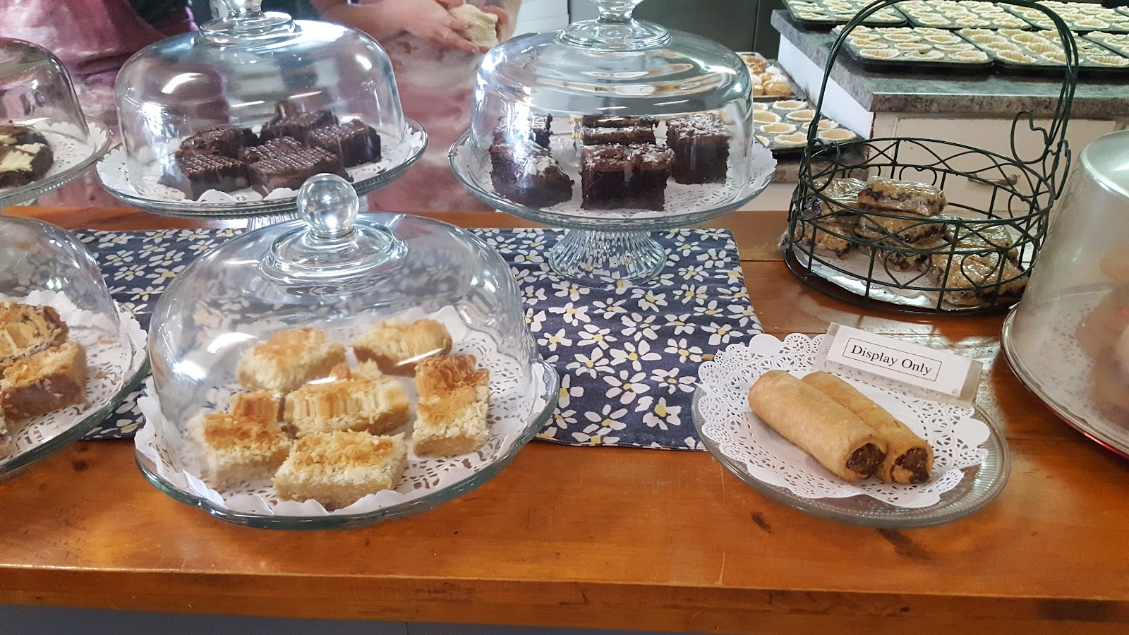 Glass-domed cake stands of squares and pastries on the bakery counter