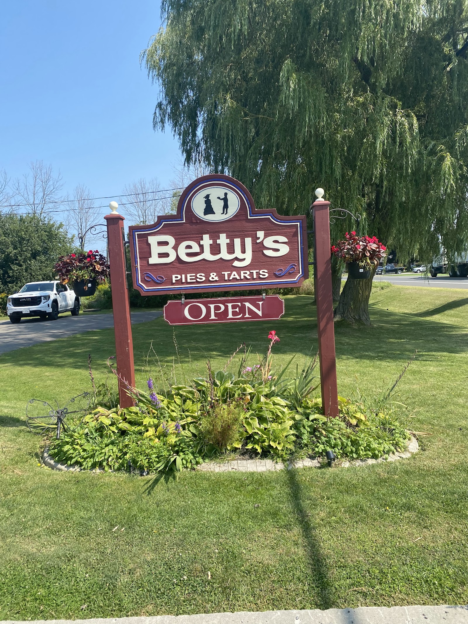 The maroon roadside sign reading Betty's Pies and Tarts