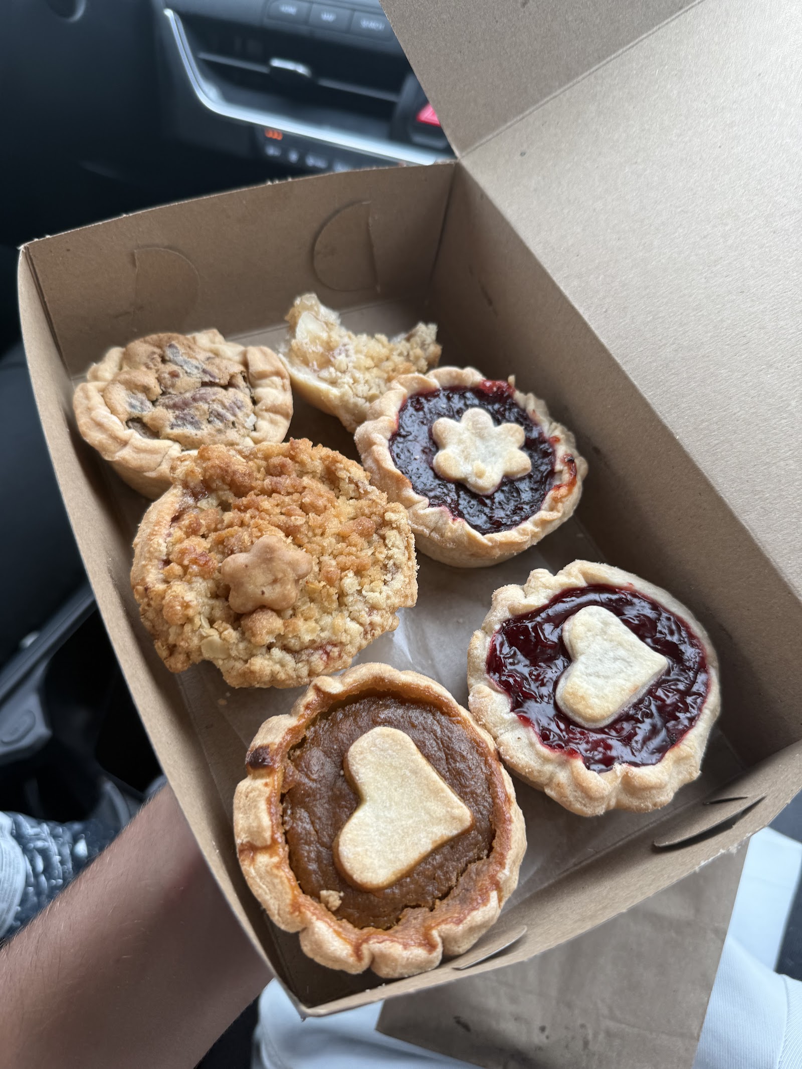 A box of assorted butter tarts from Betty's, some finished with little pastry hearts