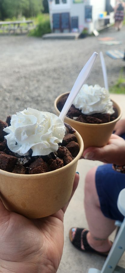 Two customers holding chocolate-cookie sundae cups at KT's Tasty Treats