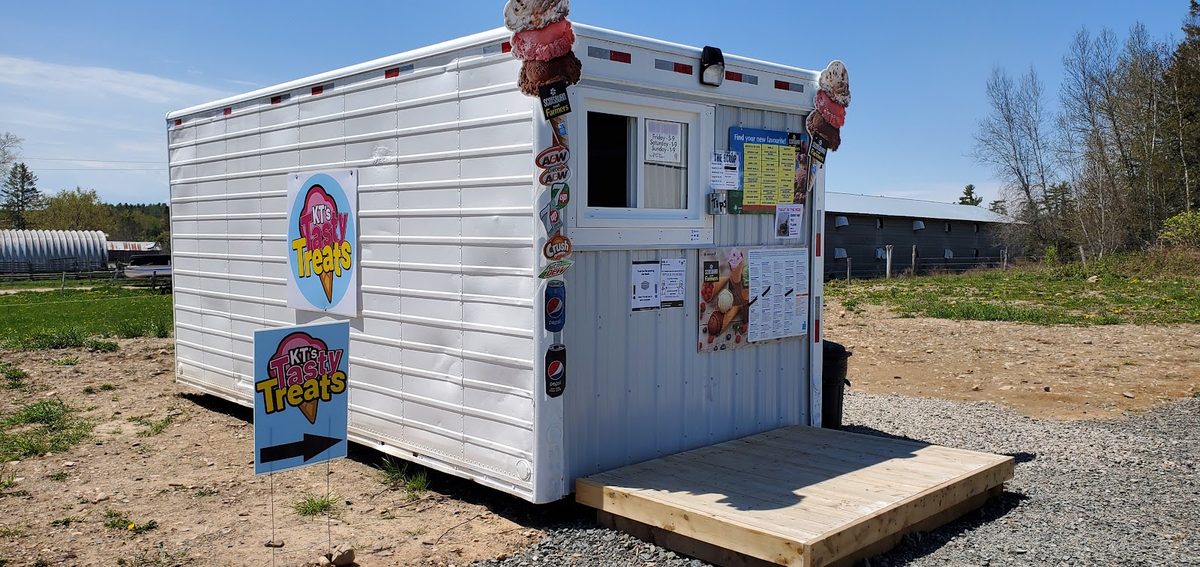 The KT's Tasty Treats roadside stand with its circular yard-sign logos
