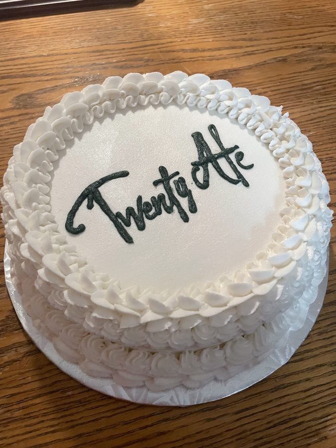 A clean white celebration cake with hand-piped script.