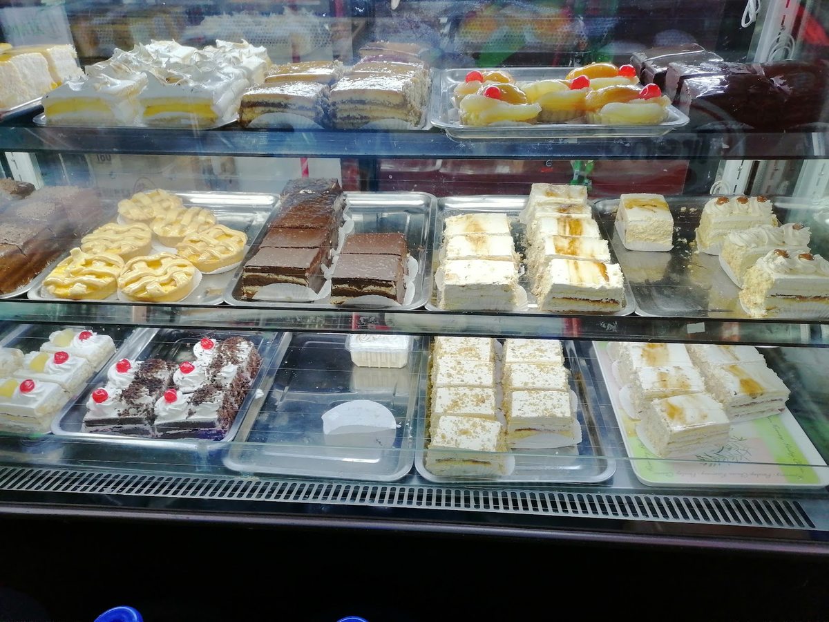 Vitrina de pastelería de Ricopan con tortas, tartaletas y pasteles del día.