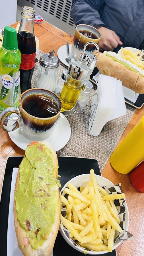 Mesa del salón de té de Ricopan: café, completo y papas fritas.