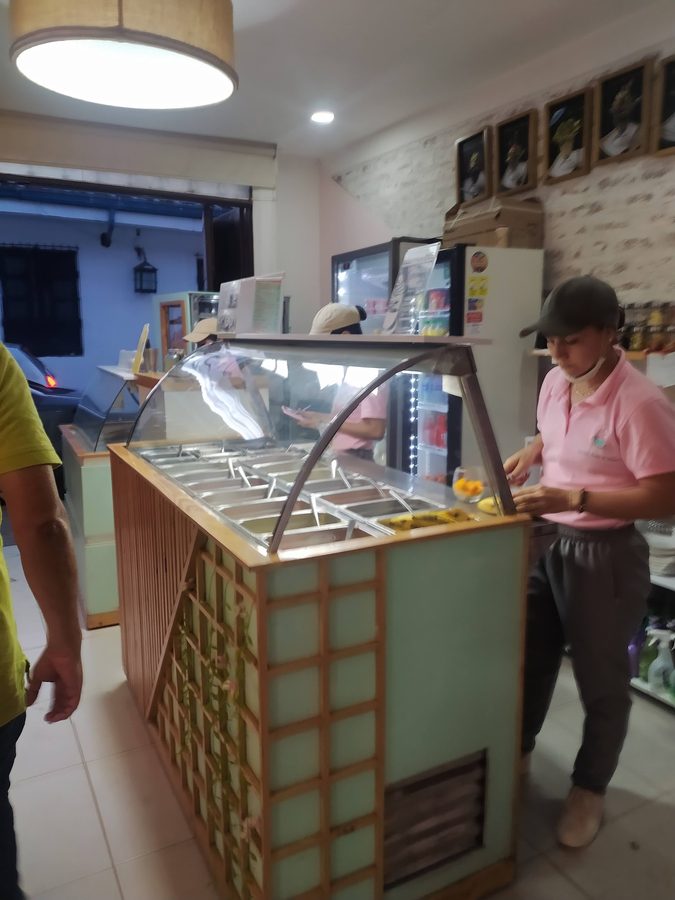 Vitrina de helados de El Reposo con una integrante del equipo sirviendo