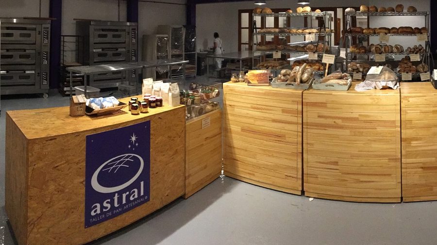 Mostrador de Astral con la marca del taller y el pan del día detrás.