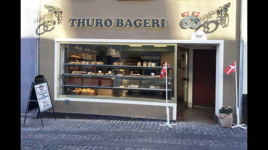 Friskbagt brød på hylderne set gennem butiksvinduet
