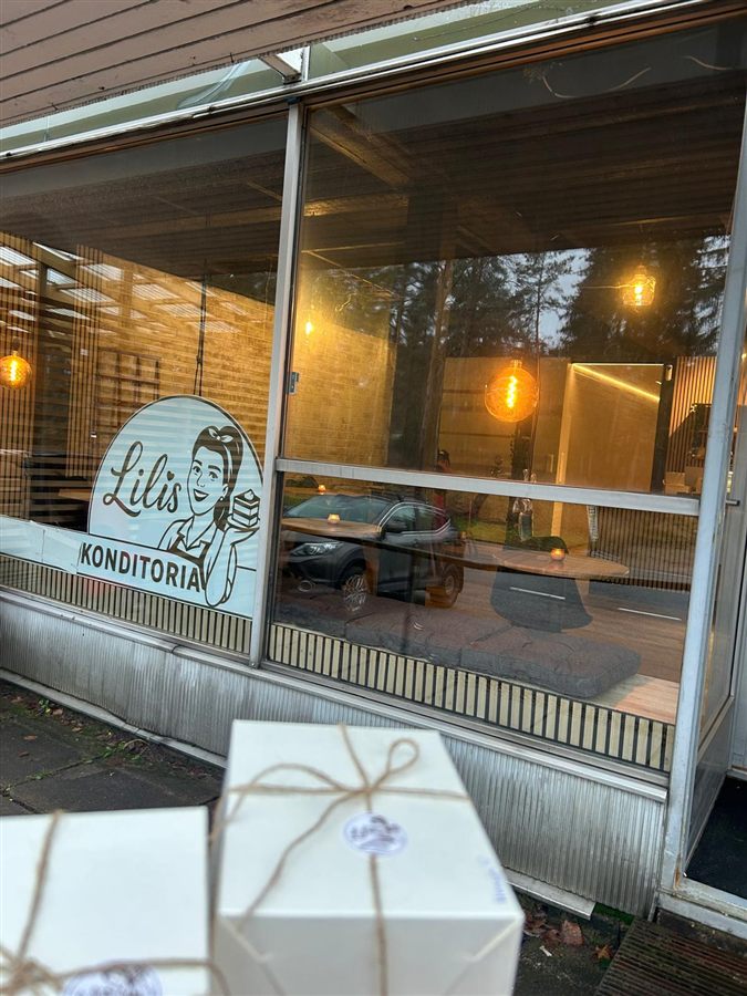 Lahjaksi paketoituja kakkulaatikoita Lilis-tarralla liikkeen edessä.