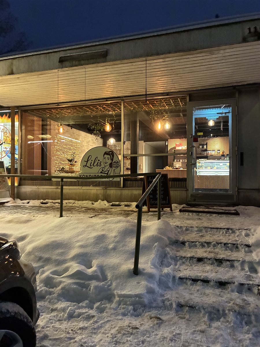 Lilis Konditorian valaistu julkisivu lumisena talvi-iltana Söderkulassa.