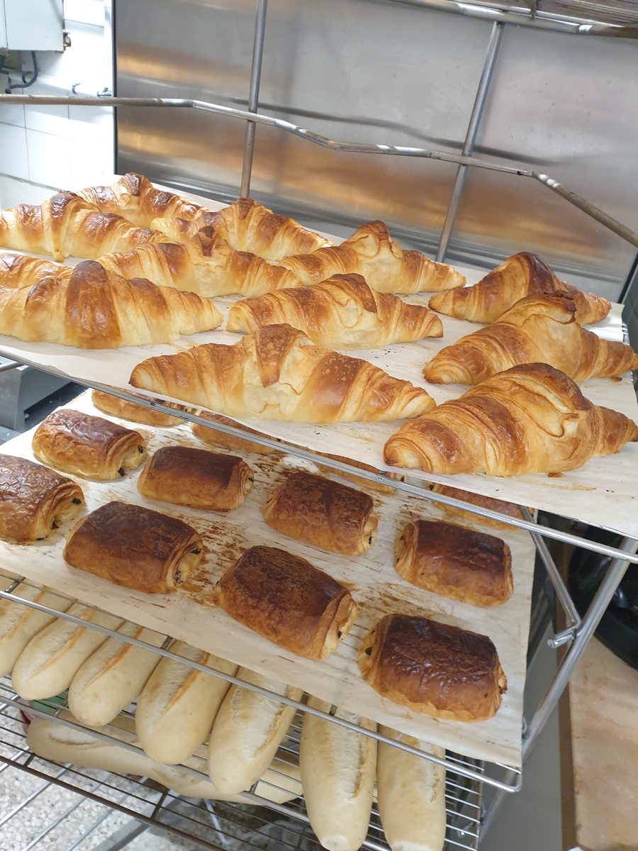 Tray of fresh croissants, pains au chocolat, and baguettes