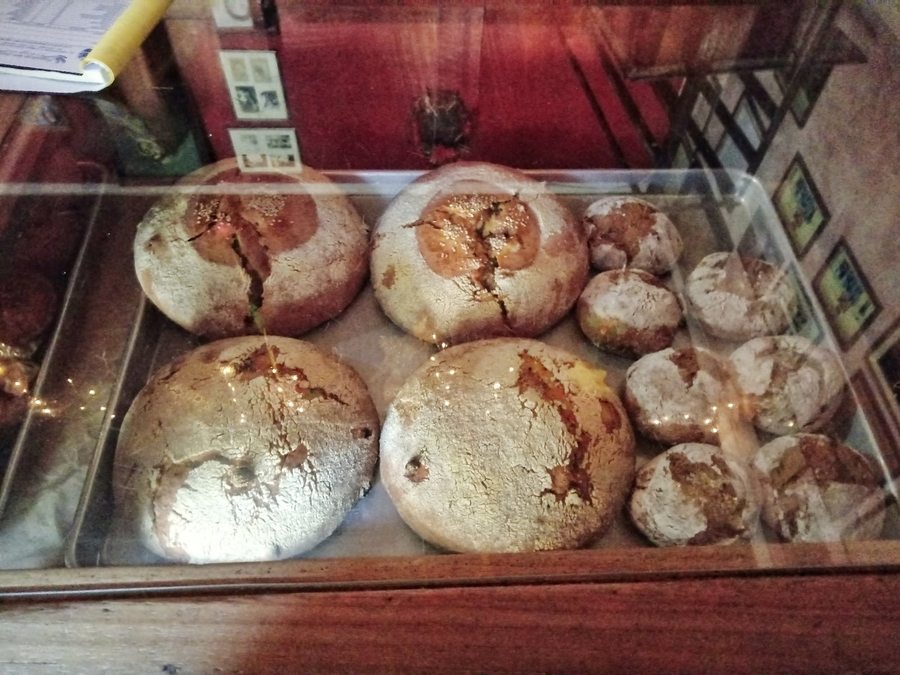Pan artesanal recién horneado, con corteza enharinada y miga dorada, hecho en horno de leña