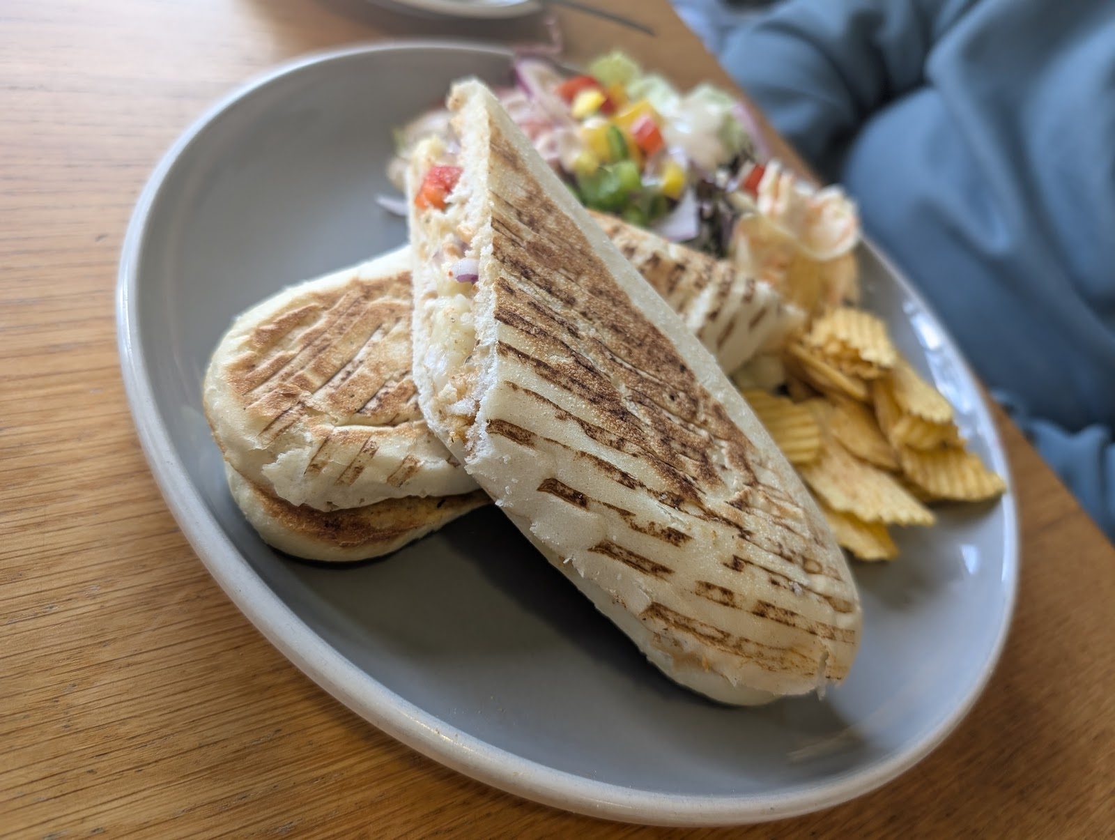 A toasted panini with a side salad and crisps at Goodies