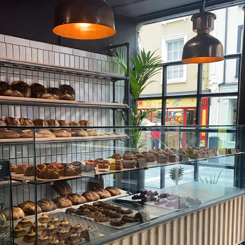 Bakery interior with shelves of sourdough and copper pendant lights