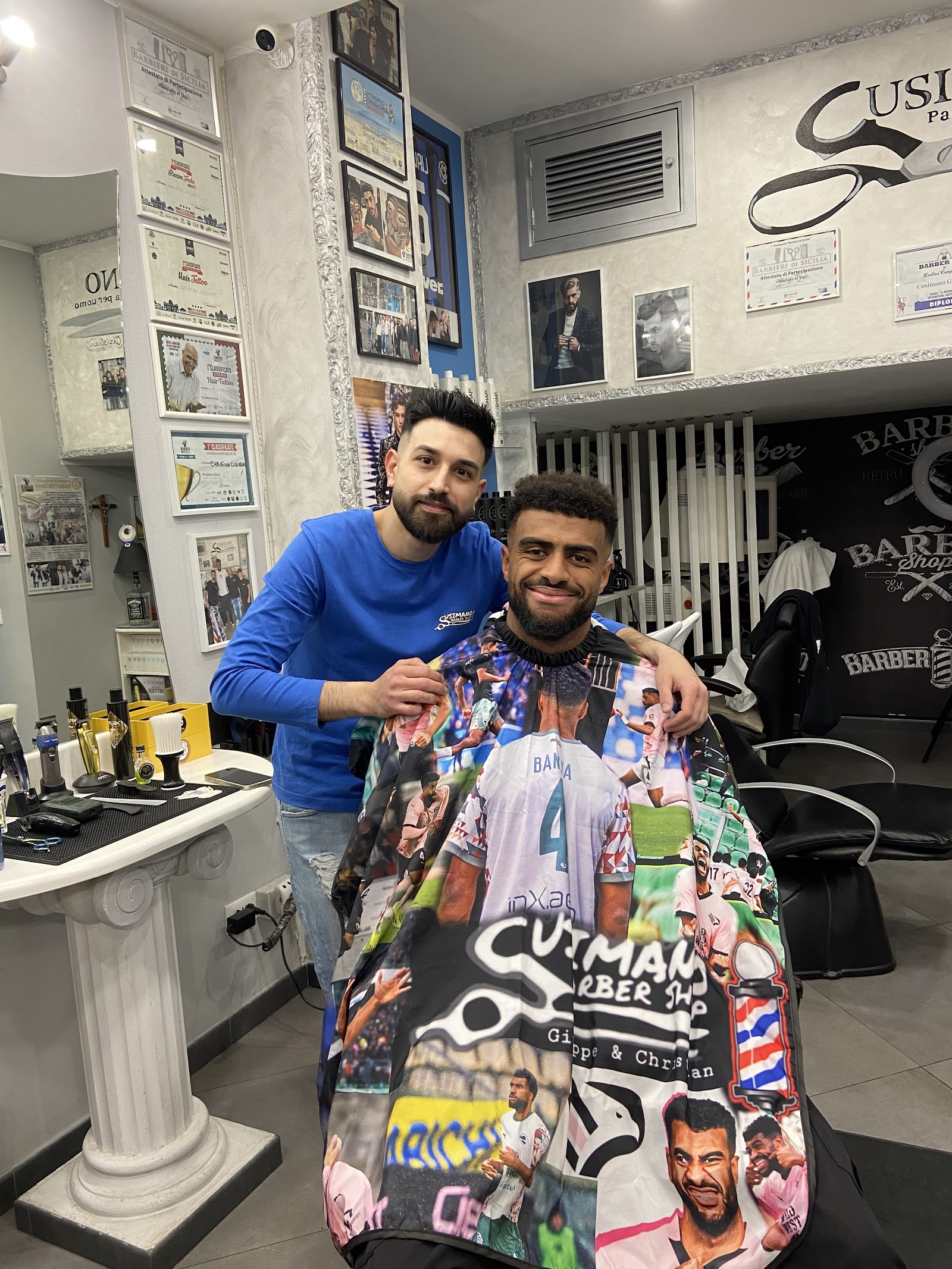 Giuseppe Cusimano al lavoro nel salone, con i premi alle pareti