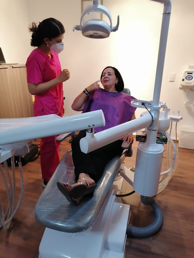 Consultorio de Dental AD: sillón dental moderno y personal atendiendo a una paciente