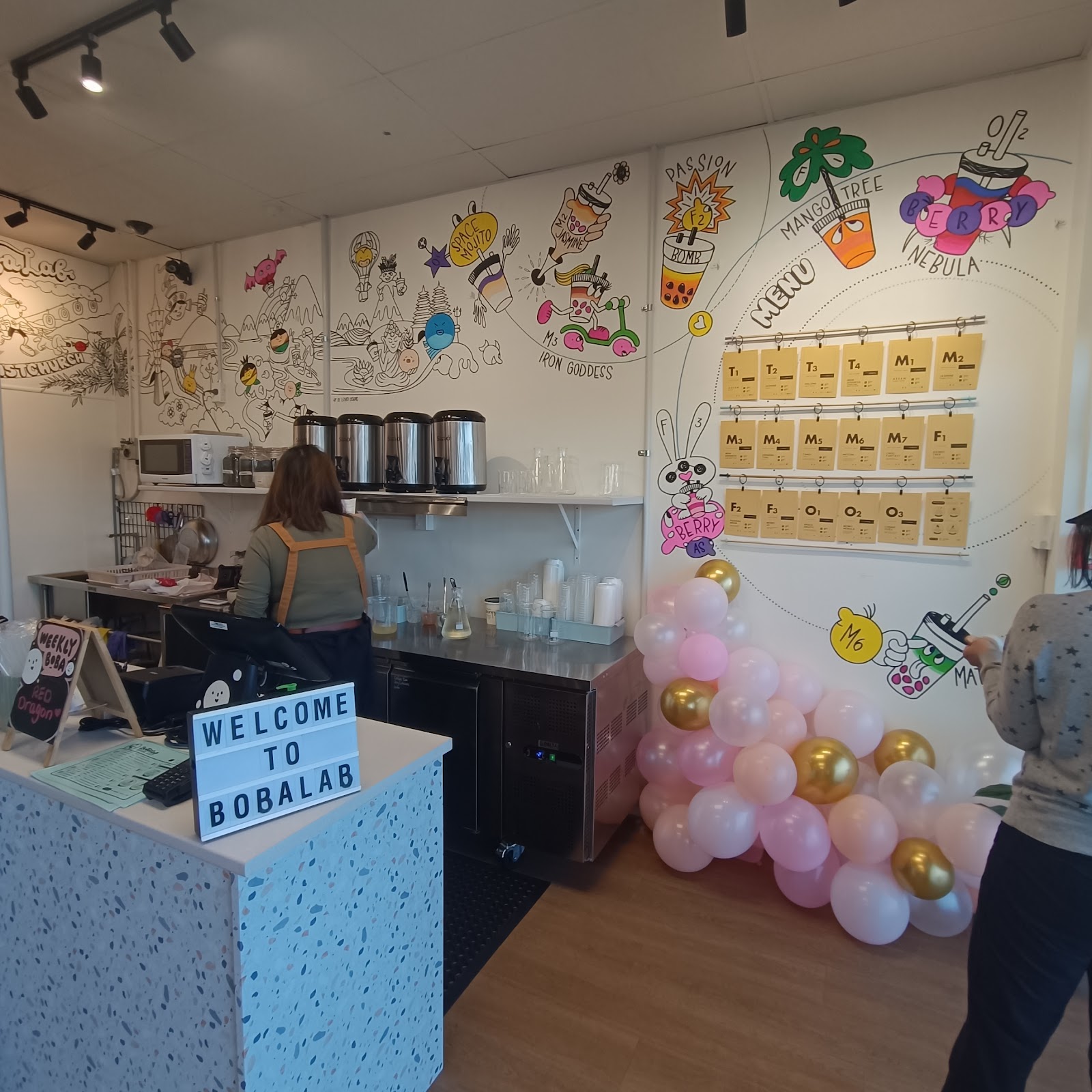 Inside BobaLab — the illustrated menu wall and counter.