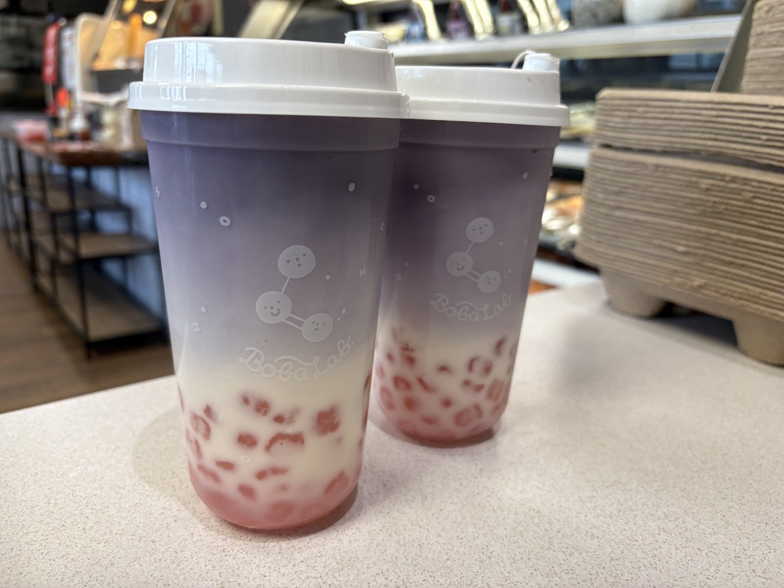 Two branded BobaLab cups with strawberry-pink boba.