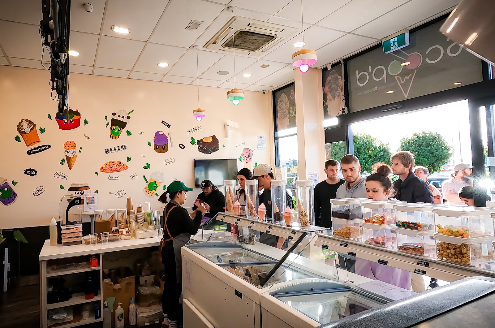 Inside Scoop'd — counter, ice cream display and colourful wall art