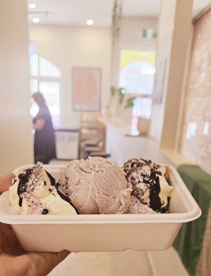 A scooped ice cream cup with chocolate drizzle