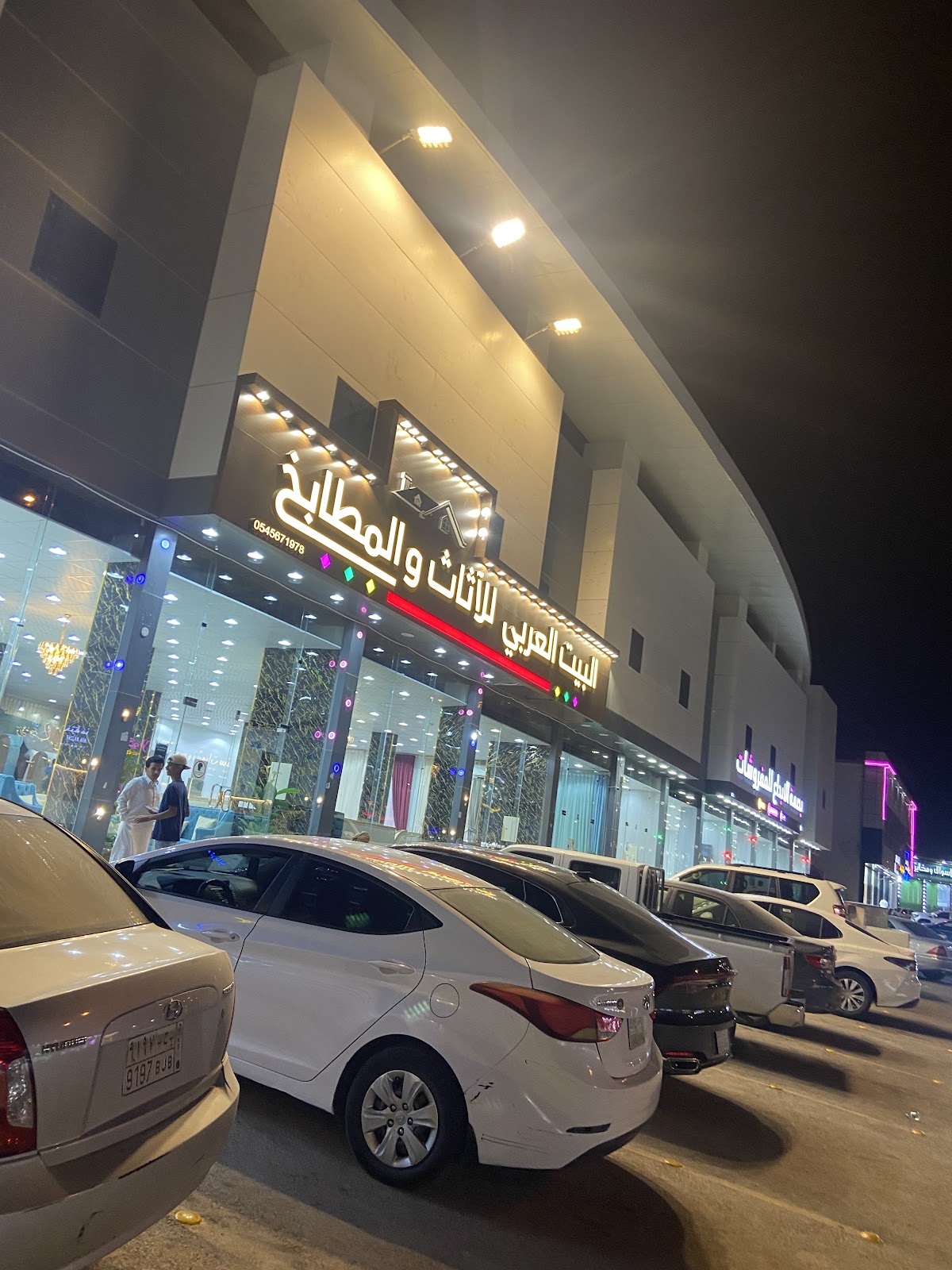 واجهة المحل ليلًا بلوحة الاسم المضيئة