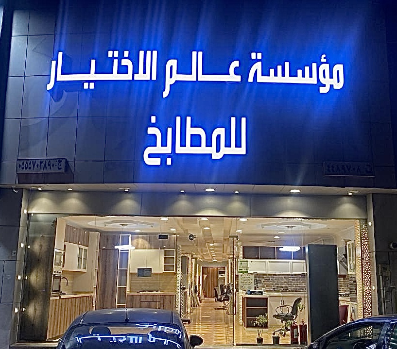 واجهة صالة العرض ليلاً واسم المؤسسة مضاء باللون الأزرق