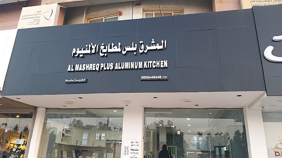 واجهة المعرض بلوحة داكنة وزجاج يظهر خلفه مطابخ العرض