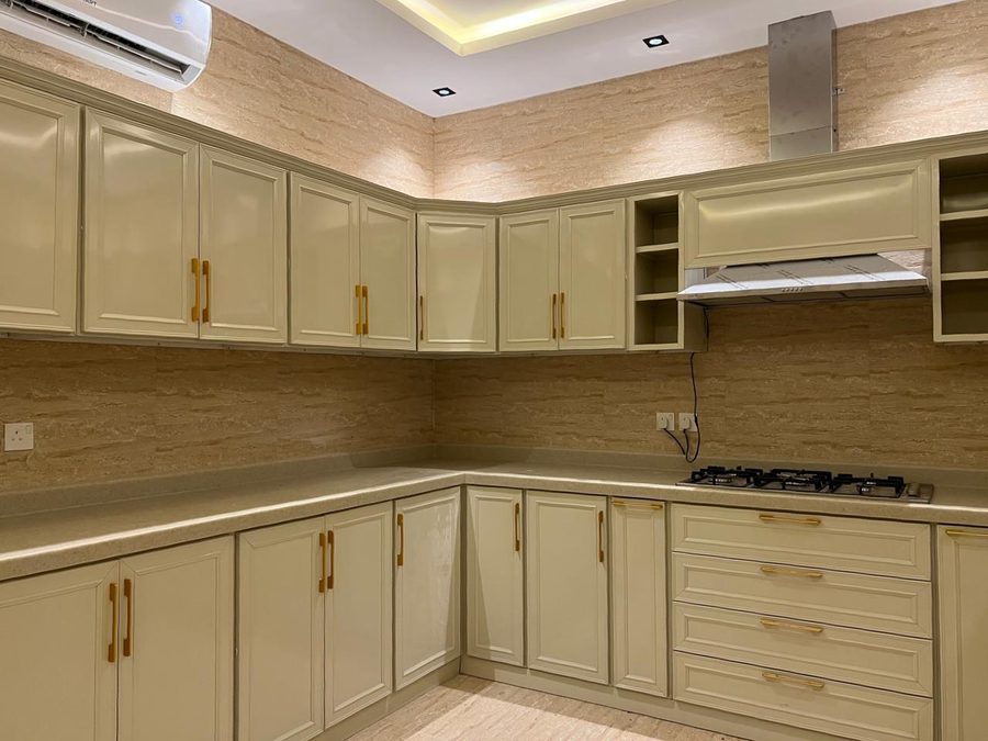 مطبخ كلاسيكي بواجهات كريمية بإطار ومقابض ذهبية