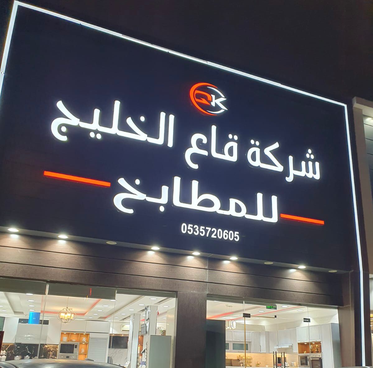 واجهة معرض قاع الخليج للمطابخ ليلًا بلافتة مضيئة فوق صالة العرض