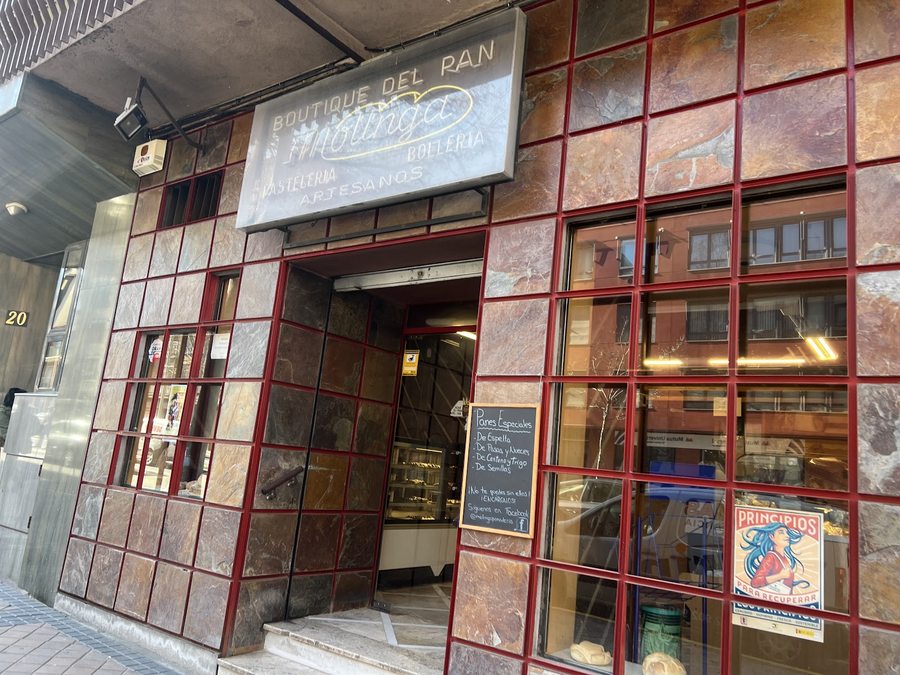 Fachada de Panadería Pastelería Molinga en Segovia, con el rótulo de la casa y pan en el escaparate.