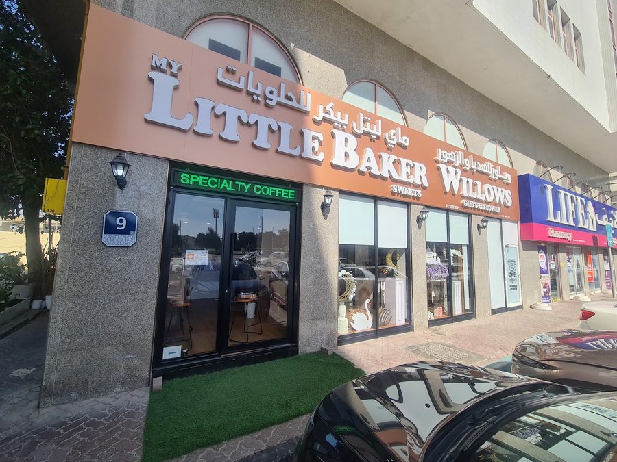 واجهة المحل نهاراً — storefront by day with bilingual signage