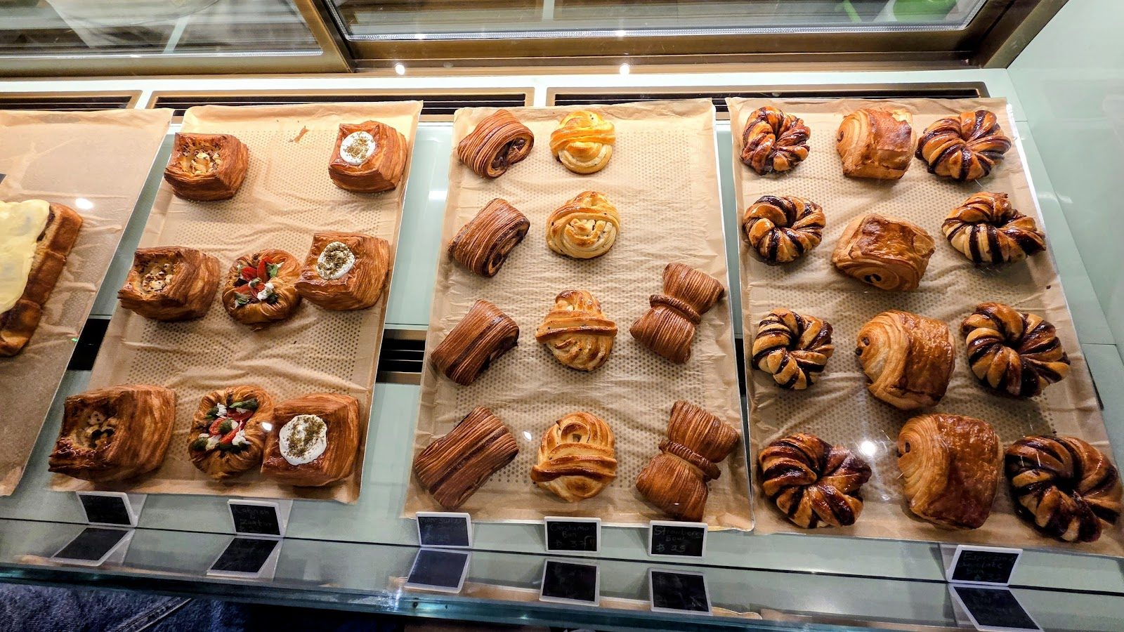 Fresh laminated pastries — danishes, croissants and swirl rolls — in the display case
