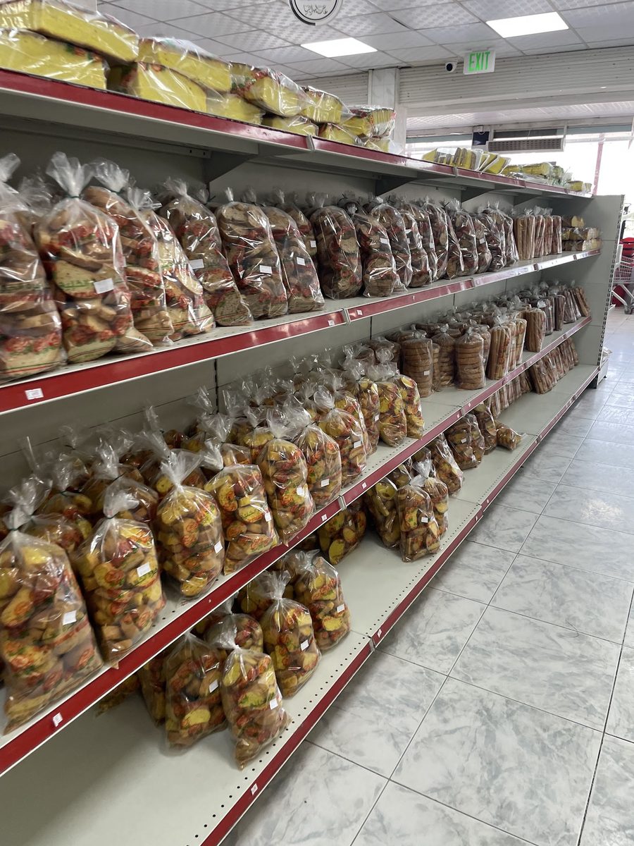 رفوف مليئة بالخبز والبقسماط والبسكويت الطازج داخل المخبز / Shelves of freshly baked breads, rusks and biscuits inside the bakery