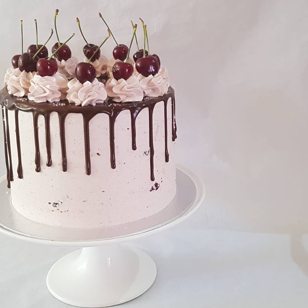 Cherry-topped drip celebration cake
