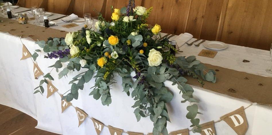Wedding reception flowers with trailing eucalyptus