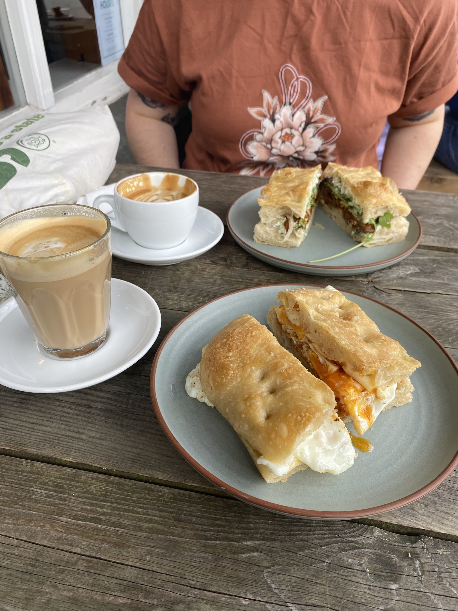 Two focaccia sandwiches with generous fillings on ceramic plates