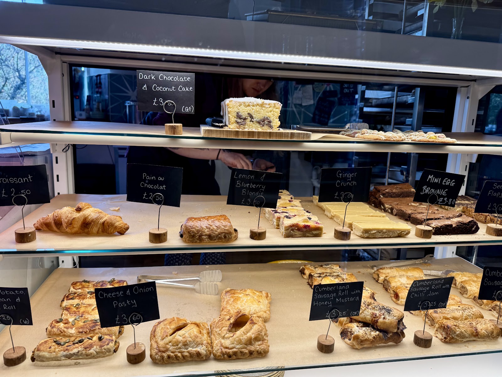 Lucia's bakery display case filled with sausage rolls, ginger crunch, brownies and pastries