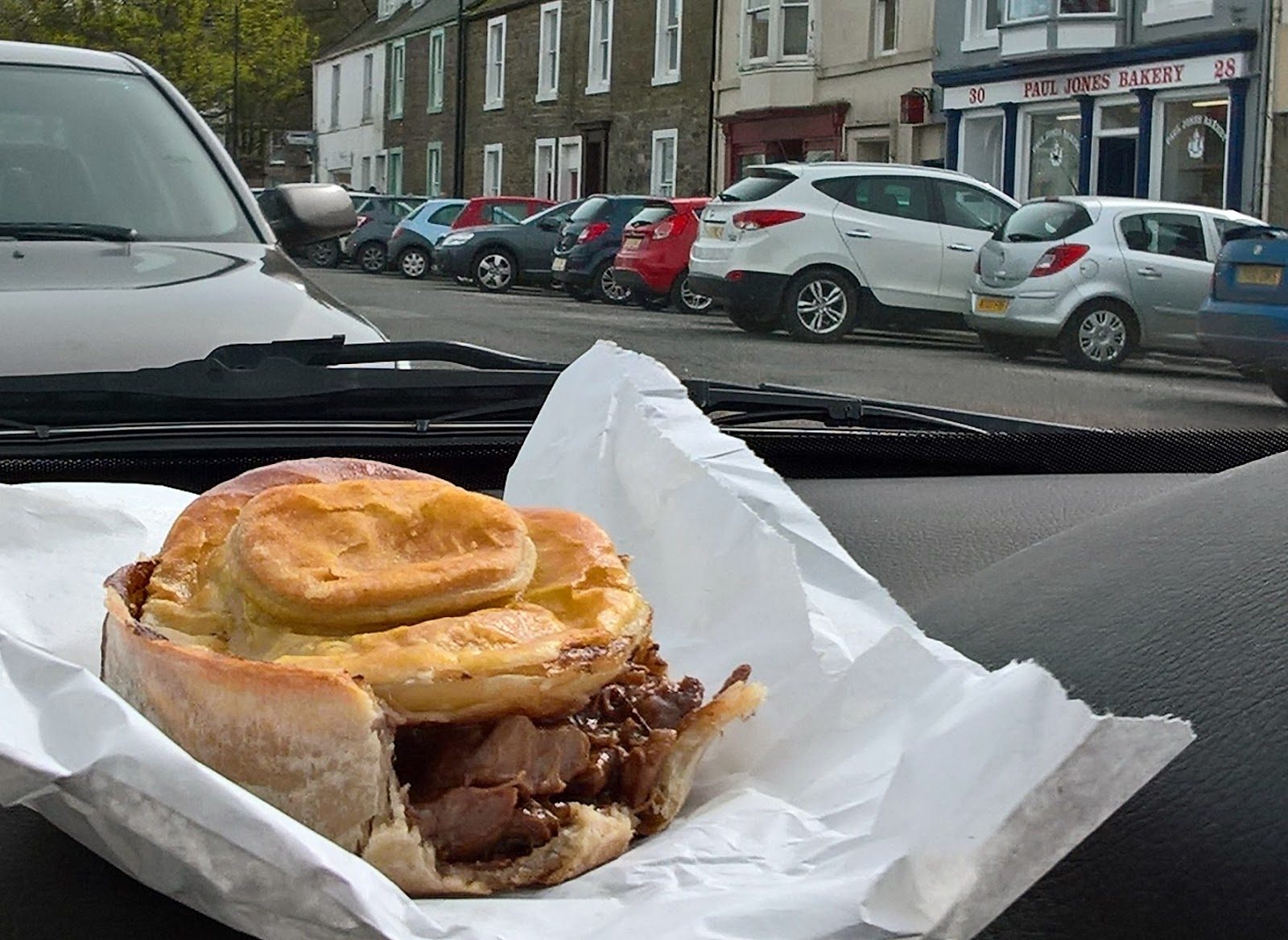 A golden Paul Jones Bakery steak pie with a proud puff-pastry lid, fresh from the bag