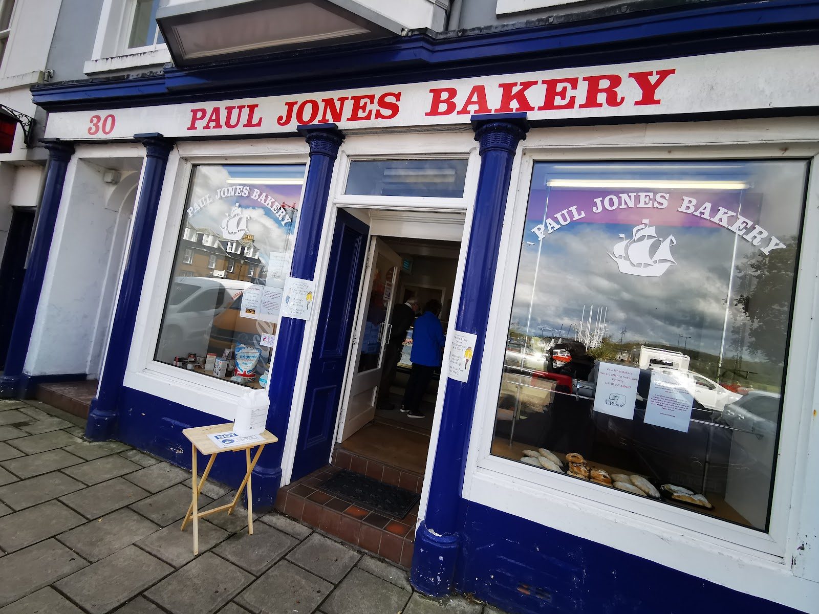 Paul Jones Bakery with its door open on St Cuthbert's Street, the ship window decal visible