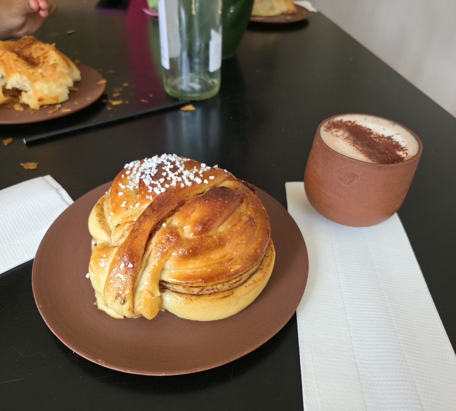 A Swedish cardamom bun with pearl sugar and a flat white at Flori Bakery