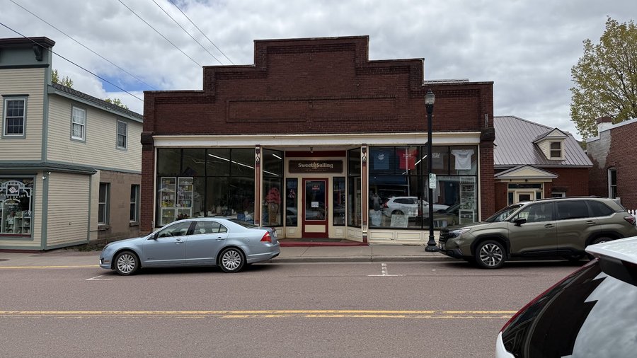 Sweet Sailing brick storefront and painted sign on Rittenhouse Avenue in Bayfield