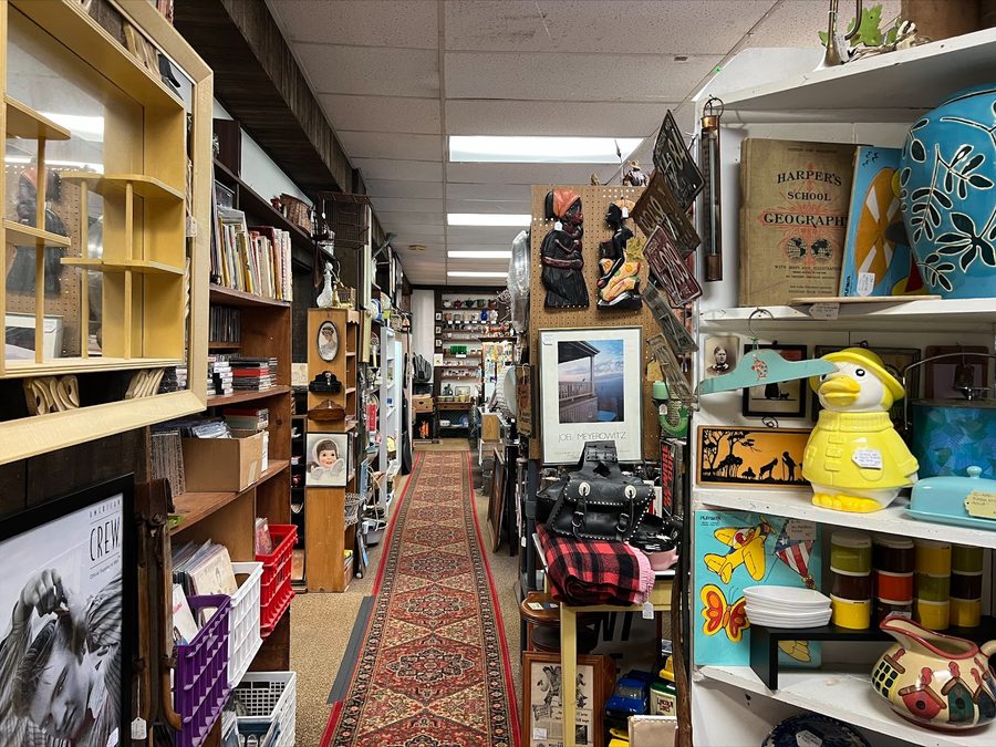 A curated aisle of books, glassware and collectibles at Creekside Vintage
