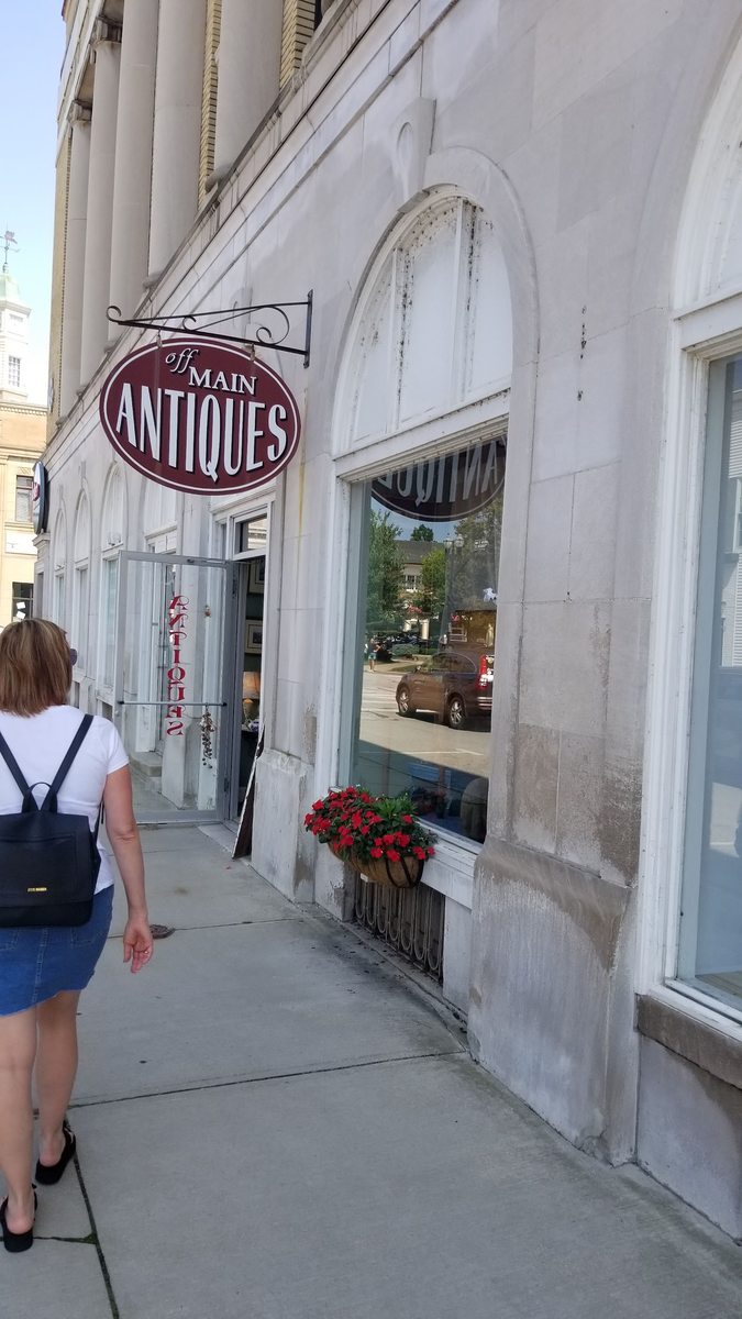 The Off Main Antiques storefront with its oval hanging sign in downtown Chagrin Falls