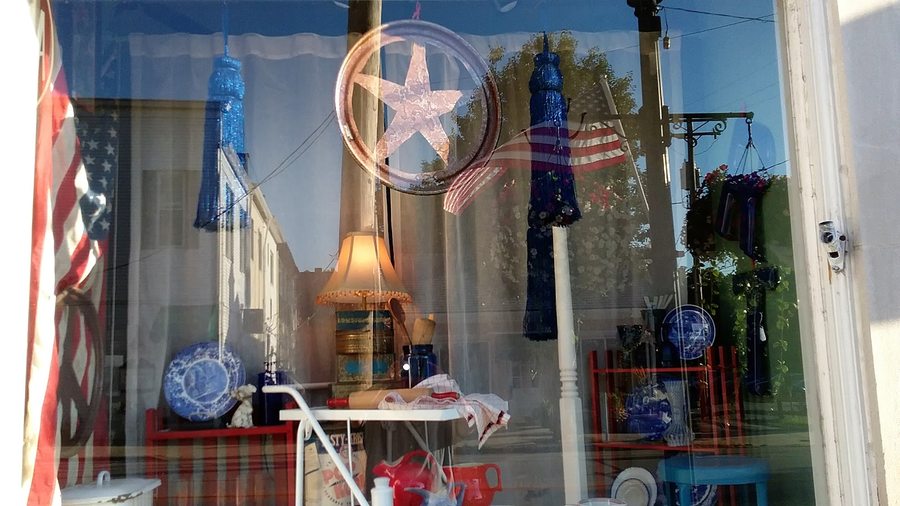 Assorted finds arranged in the shop window — lamp, tableware and seasonal pieces