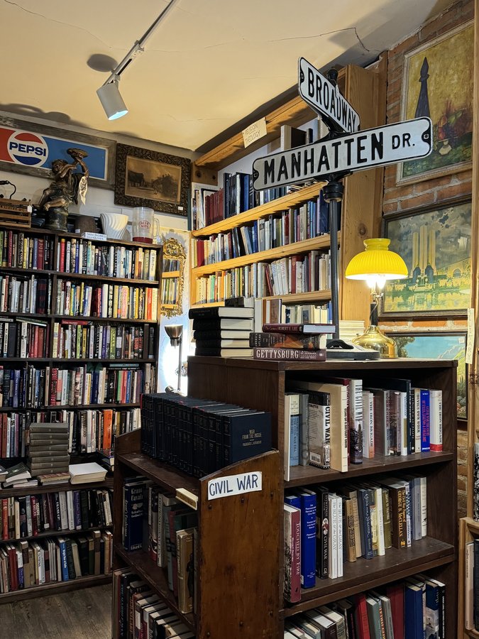 A bookshelf section labeled Civil War with vintage titles, street signs and framed art
